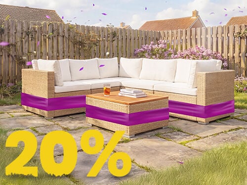 Rattan hj&oslash;rnesofa til haven med beige hynder og tr&aelig;bord p&aring; solrig terrasse, omgivet af blomster og tr&aelig;hegn, med banner for 20 % for&aring;rsrabat.