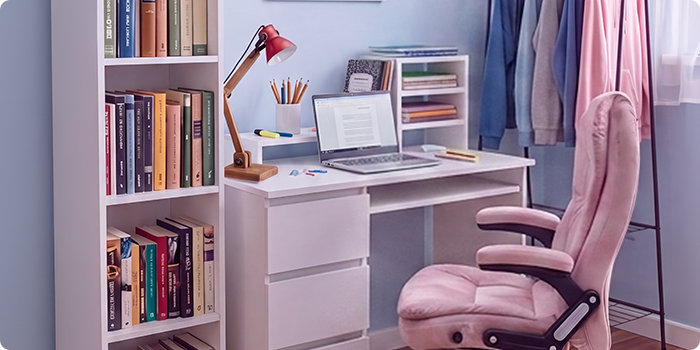 Moderne studieplads til studerende med et hvidt skrivebord, ergonomisk kontorstol, laptop, bogreol, opbevaringsmøbel og tøjstativ i et lyst og organiseret soveværelse, der er indrettet til behagelig læsning og hverdagen som studerende.